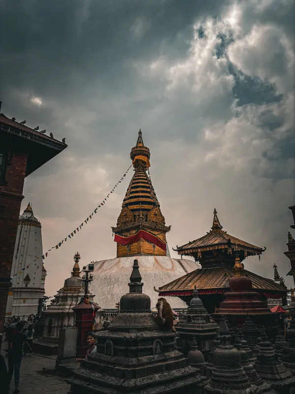 Swayambhunath stupa and shrines under heavy storm clouds